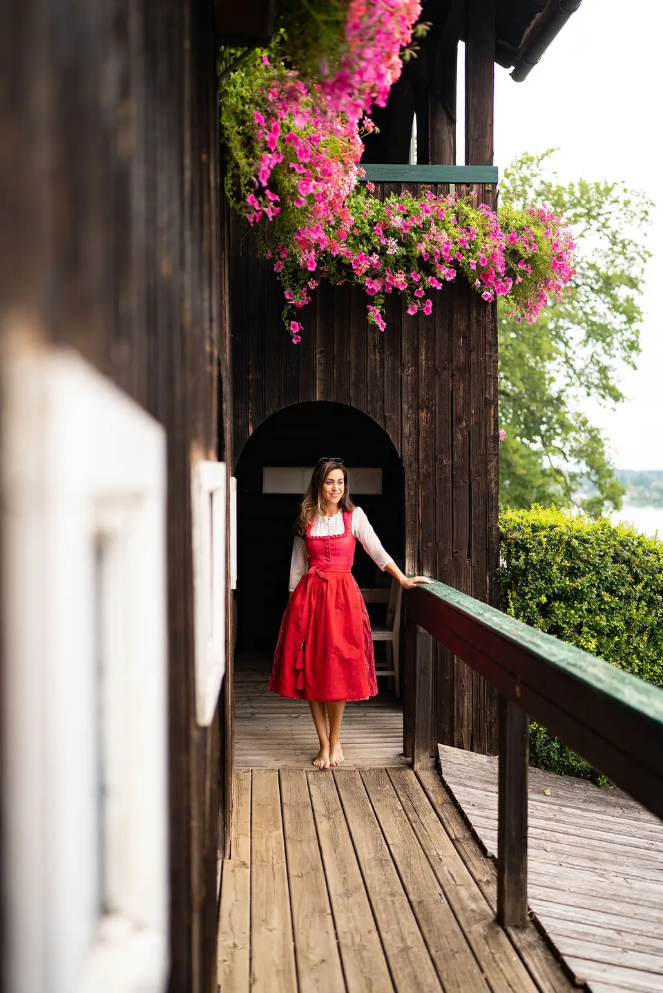 Eine Person in Tracht auf dem hölzernen Gang eines Inselgebäudes