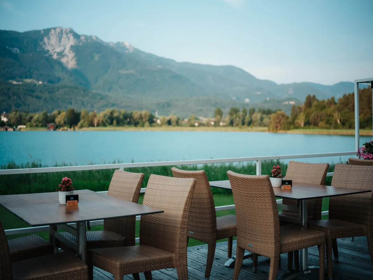 Tische auf der Seeterrasse mit freiem Blick über den Faaker See zu den Bergen
