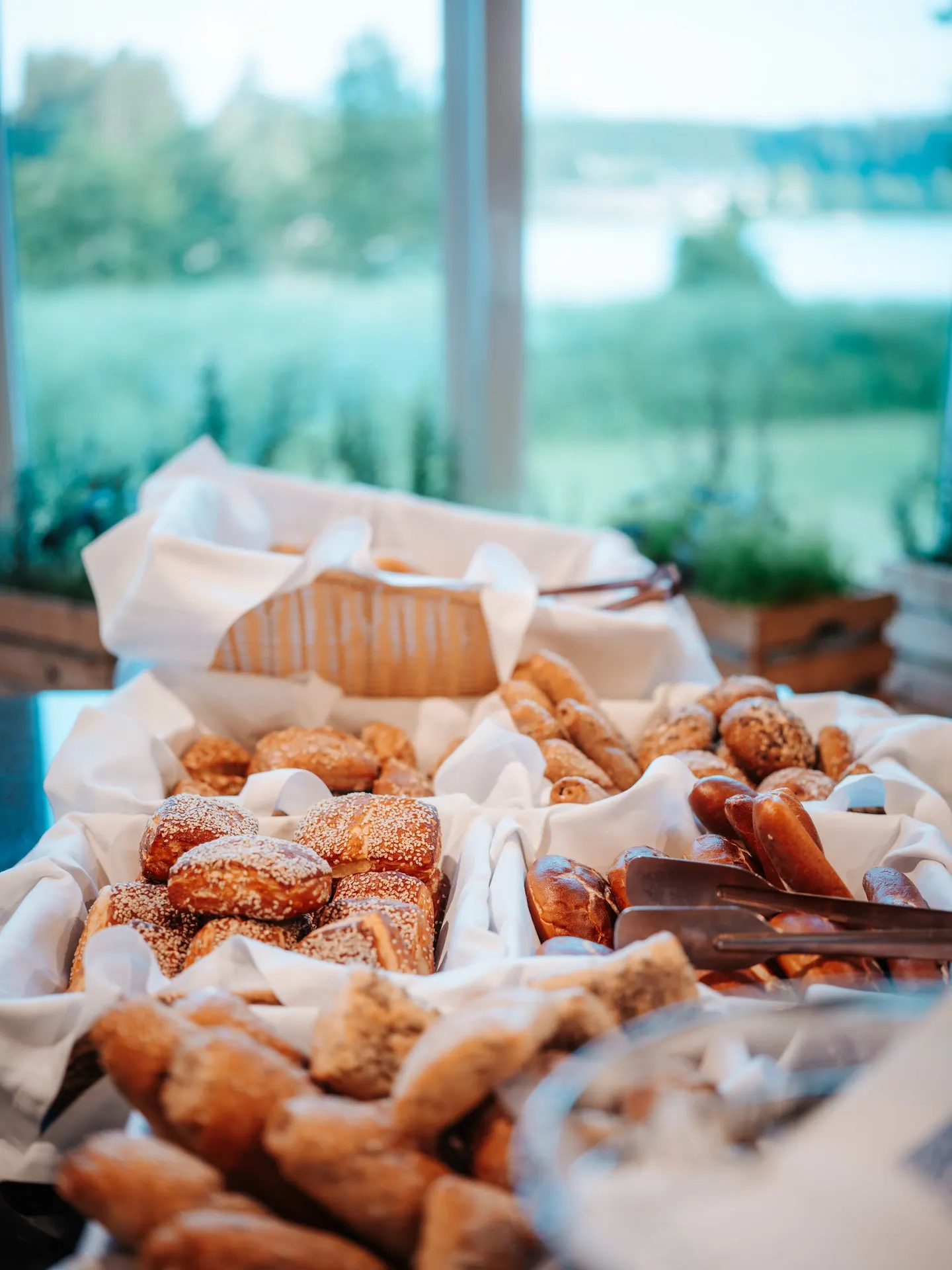 Brot und Gebäck am Frühstücksbuffet mit Blick zum See