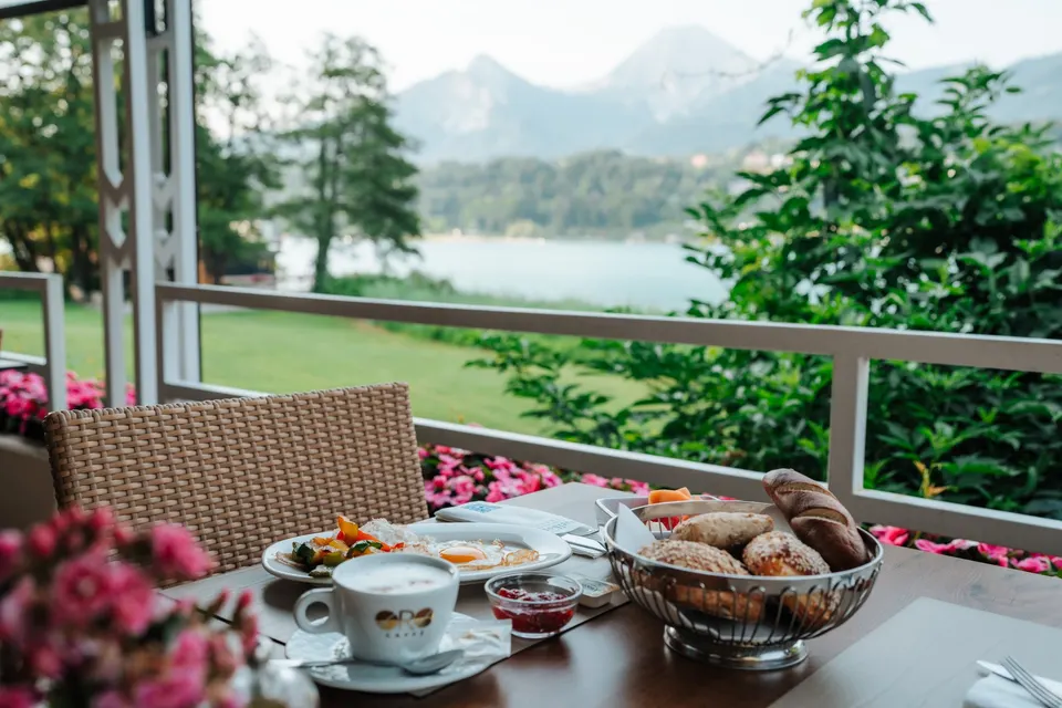 Frühstückstisch auf der Terrasse mit Blick auf See und Berge