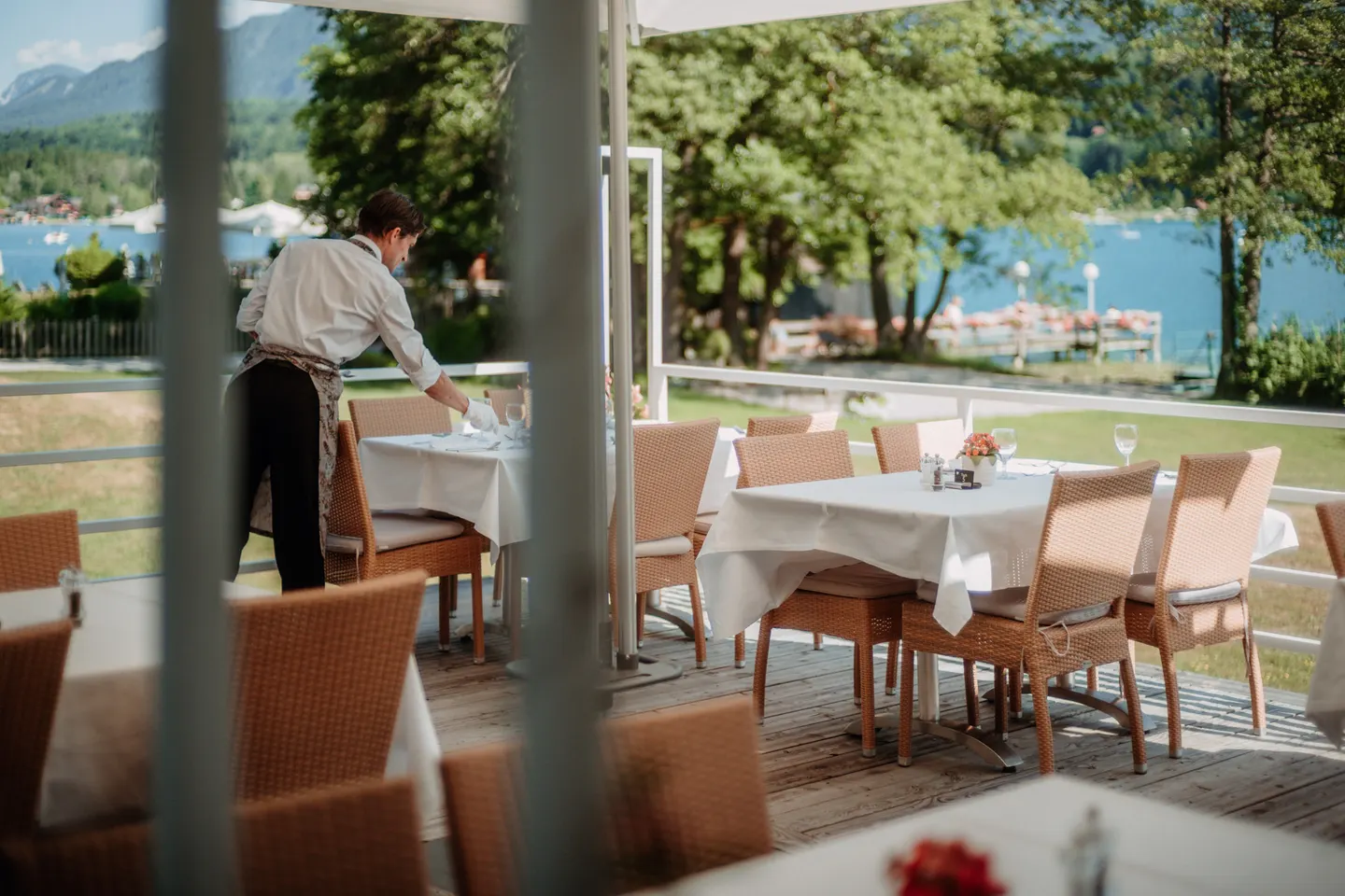Gedeckte Tische auf der Seeterrasse mit Blick auf den Faaker See