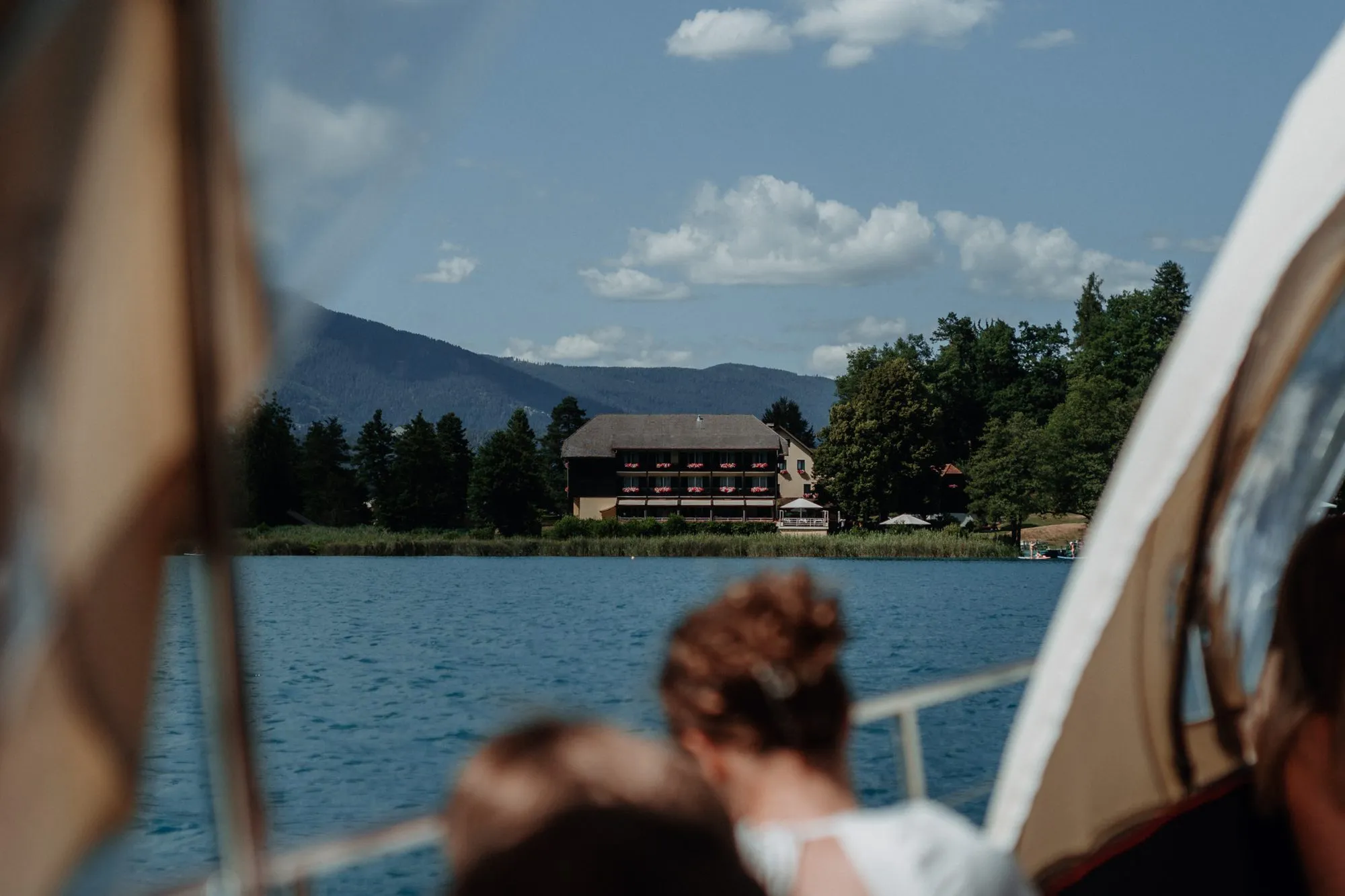 Gäste im Boot auf der Überfahrt, vor ihnen die Insel mit dem Hotel.