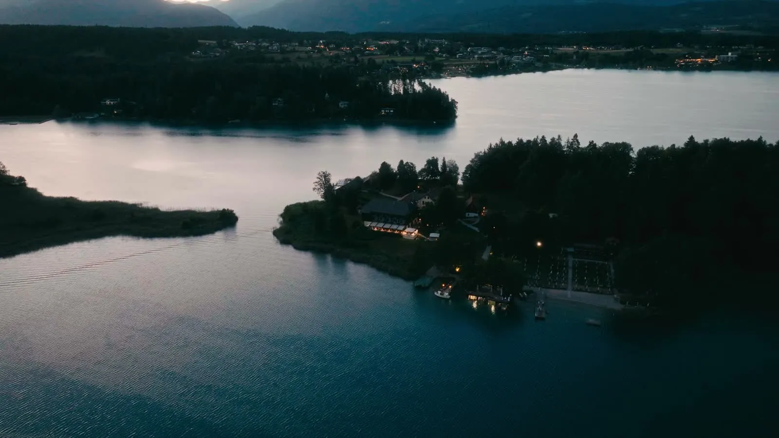 Die Insel am Abend, von oben: die Lichter des Hauses, ringsum der dunkle See.